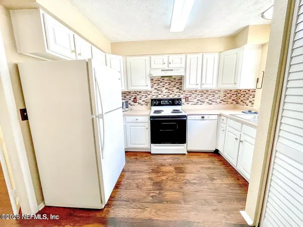 a kitchen with a refrigerator a stove a sink and a window