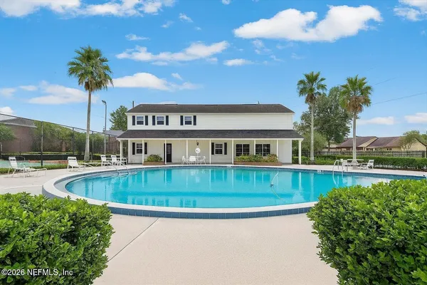 a front view of a house with swimming pool having outdoor seating