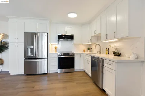 a kitchen with stainless steel appliances granite countertop a refrigerator stove and sink