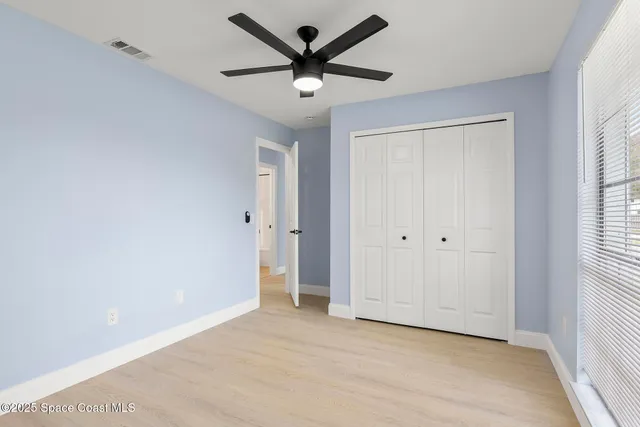 a view of a livingroom with a ceiling fan & window