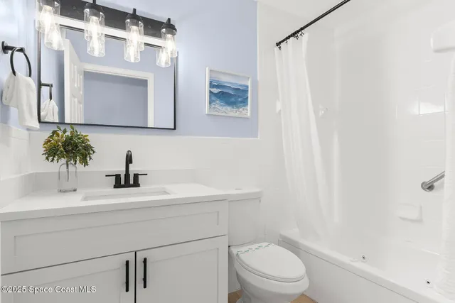 a bathroom with a sink vanity mirror and toilet