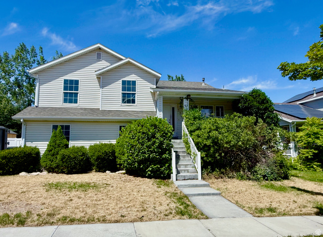 1705 80 East Tooele, UT 84074 - Photo 1 of 22 Two-story residence featuring light-colored siding, a covered porch entry, and a concrete pathway