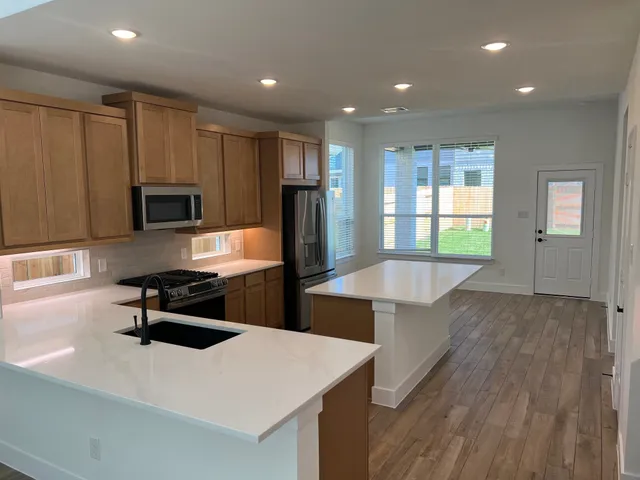 a kitchen with stainless steel appliances a microwave a stove and refrigerator