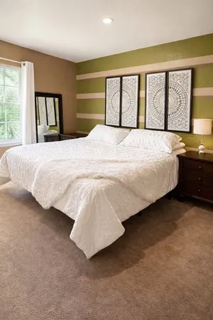 a bedroom with a large bed and large windows