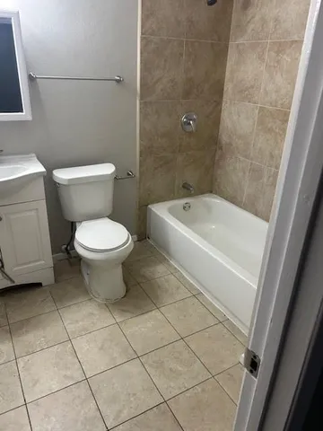 a white toilet sitting next to a bath tub