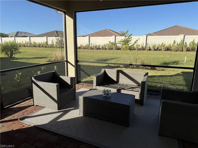 a view of a patio with lawn chairs under an umbrella