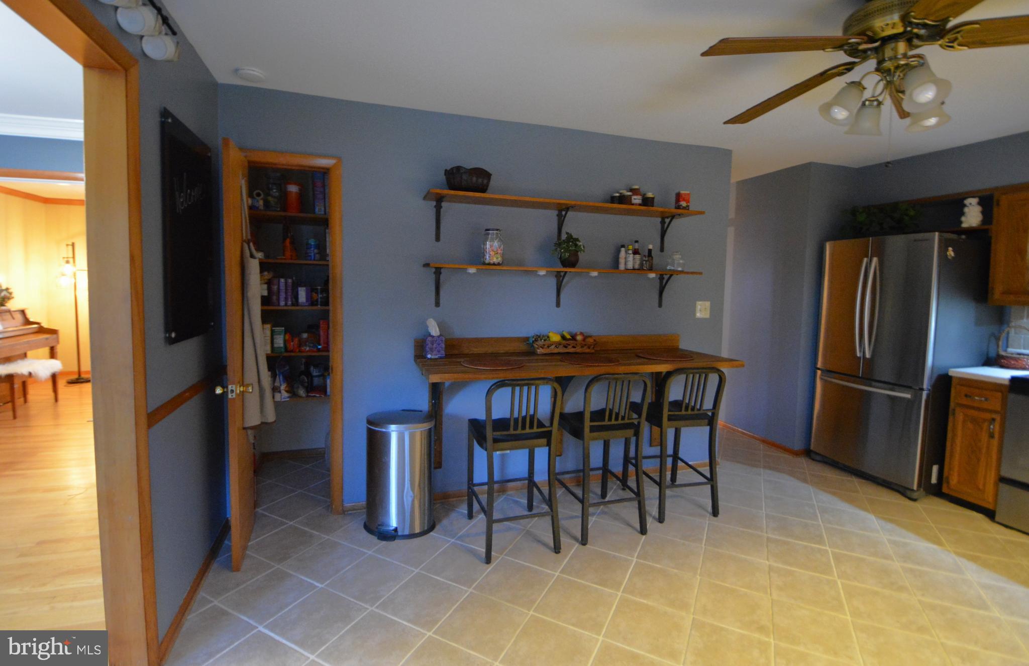 1658 Sams Creek Road Westminster, MD 21157 - Photo 13 of 59 a kitchen with stainless steel appliances kitchen island granite countertop dining table chair and a refrigerator