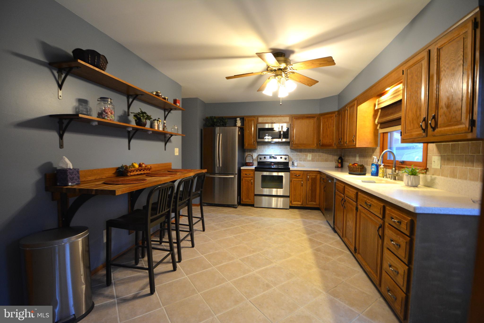 1658 Sams Creek Road Westminster, MD 21157 - Photo 10 of 59 a kitchen with stainless steel appliances granite countertop a sink a stove a refrigerator cabinets and a dining table
