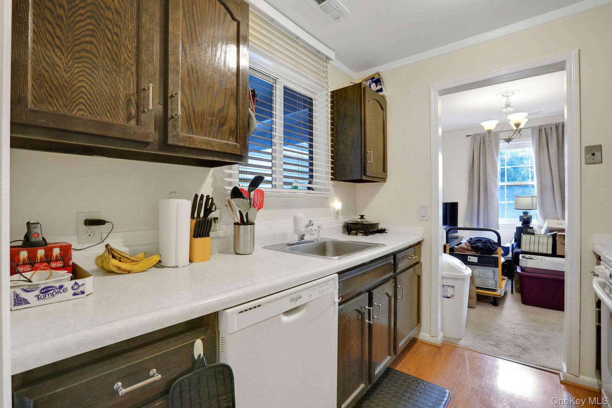 302 Commons Way, Unit E Fishkill, NY 12524 - Photo 17 of 26 Kitchen with white appliances, light countertops, ornamental molding, a chandelier, and light wood-style flooring