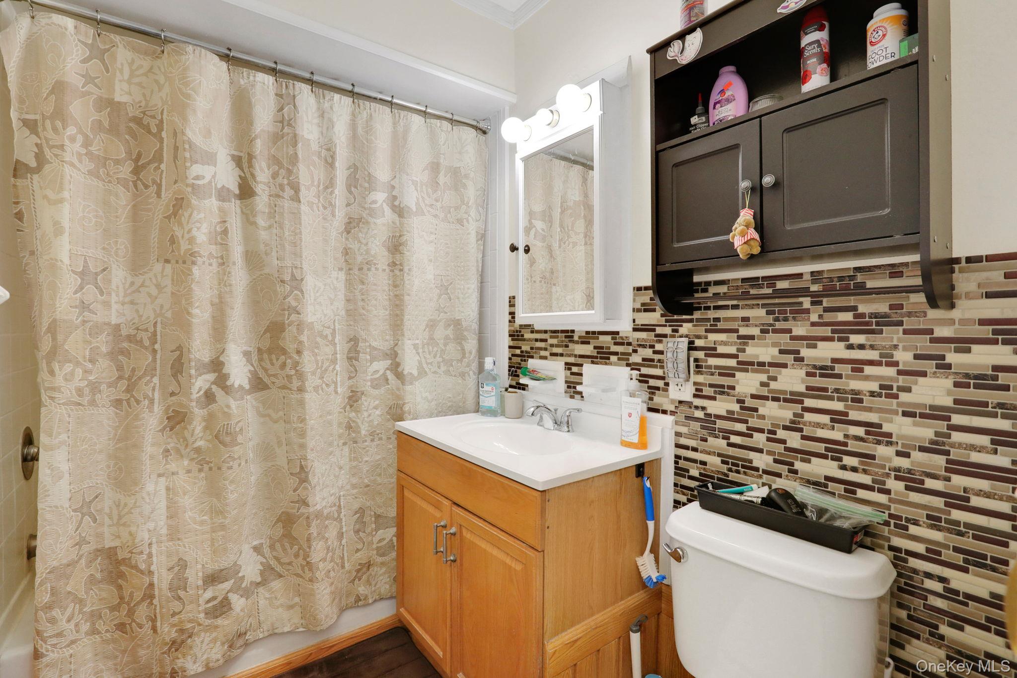 302 Commons Way, Unit E Fishkill, NY 12524 - Photo 18 of 26 Full bathroom with vanity, tasteful backsplash, shower / bath combination with curtain, and tile walls