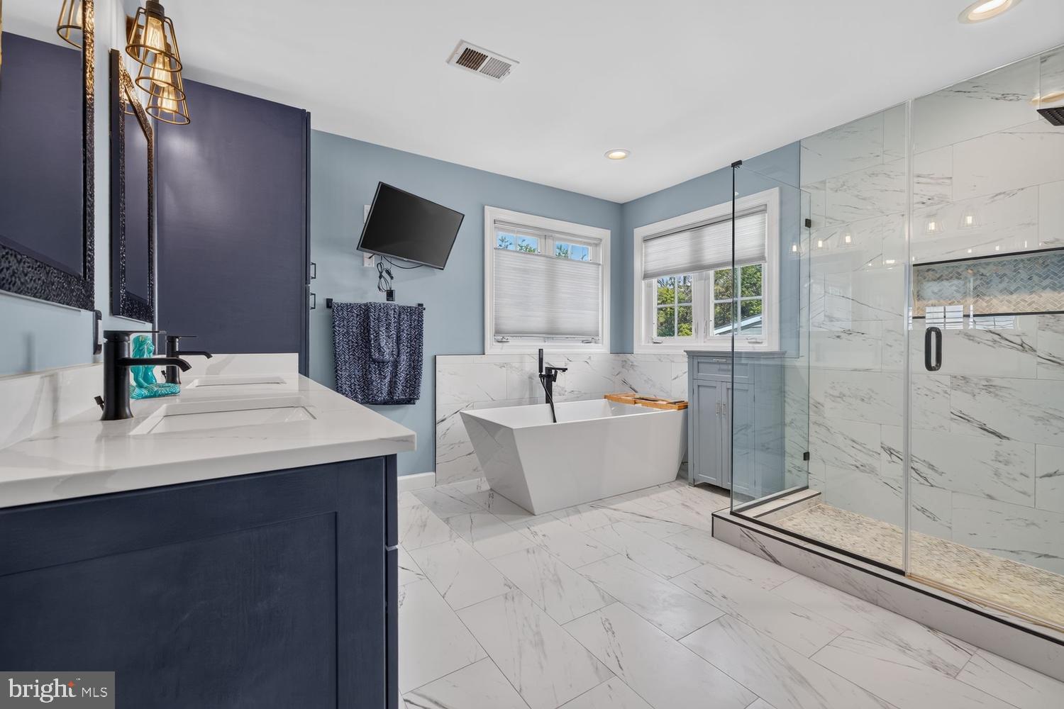 23106 Birch Mead Road Clarksburg, MD 20871 - Photo 22 of 60 a spacious bathroom with a double vanity sink a large mirror and shower