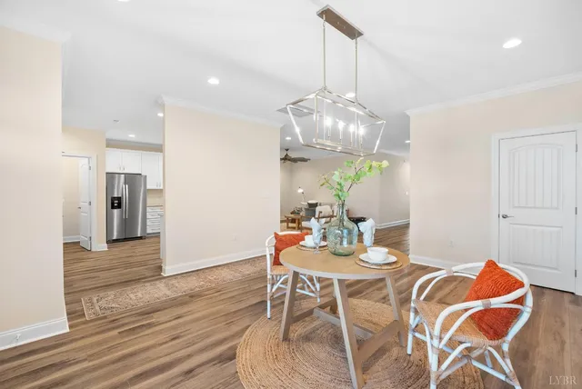 a view of a dining room and livingroom with furniture wooden floor a chandelier