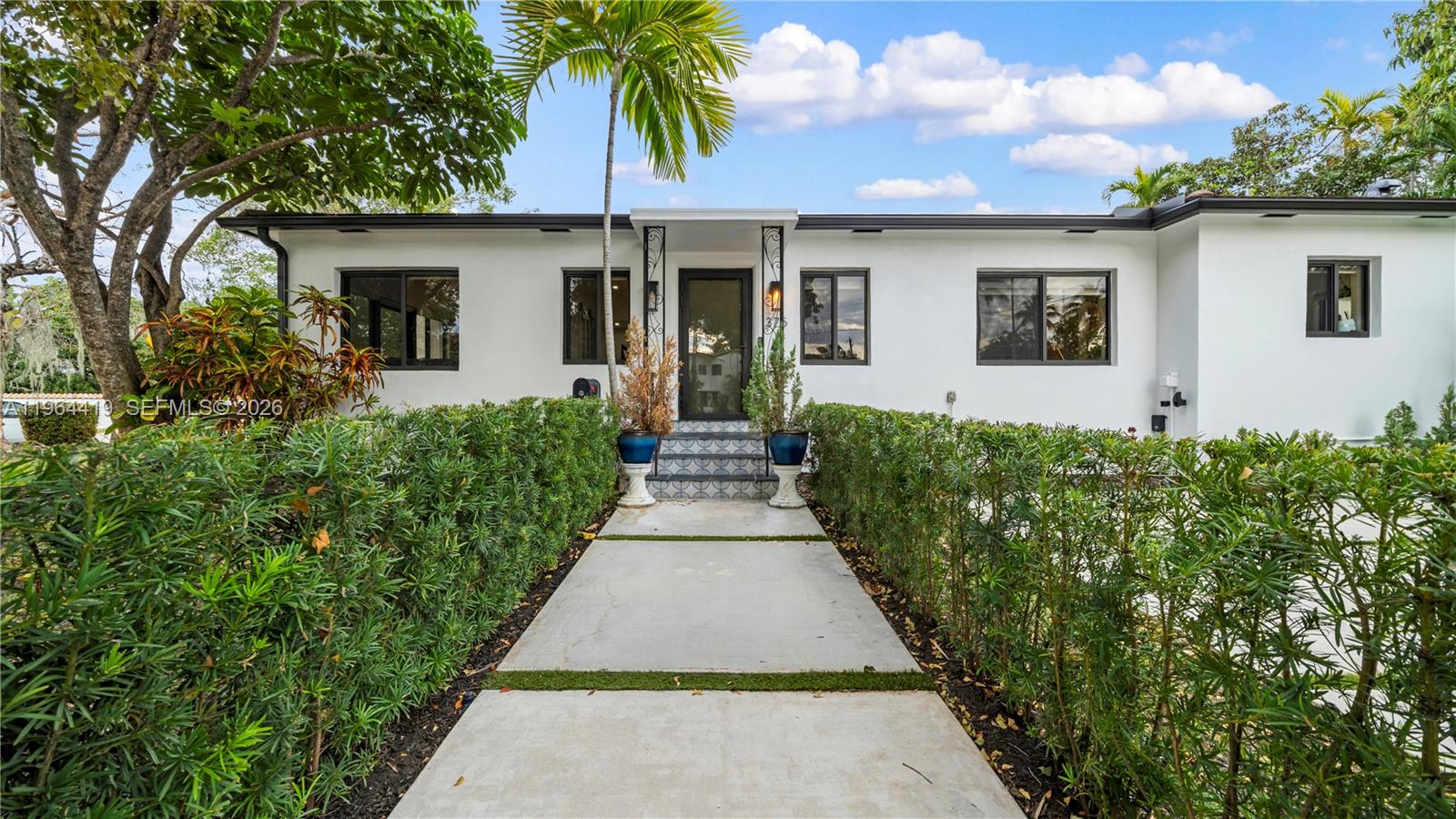 a front view of a house with a garden