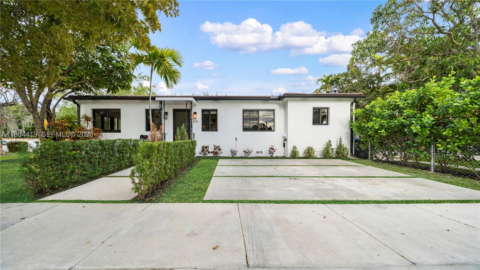 375 Southwest 32nd Road Miami, FL 33129 - Photo 2 of 39 a view of a white house with a small yard and a large tree