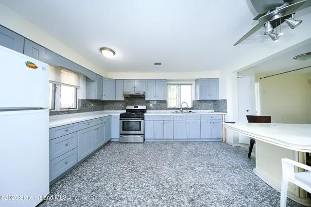a kitchen with granite countertop white cabinets and white appliances