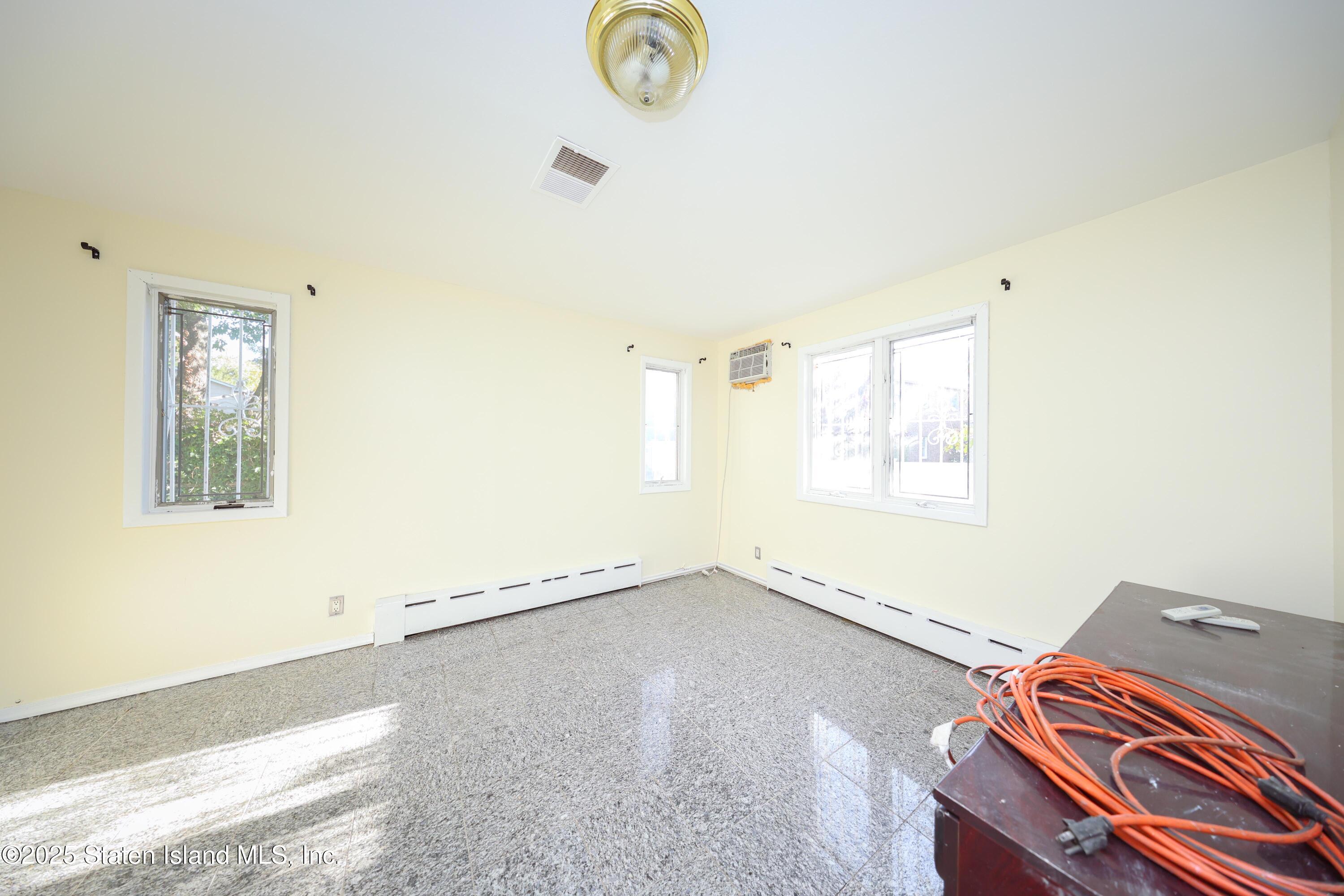 4664 Amboy Road Staten Island, NY 10312 - Photo 16 of 33 a view of a room with wooden floor and window