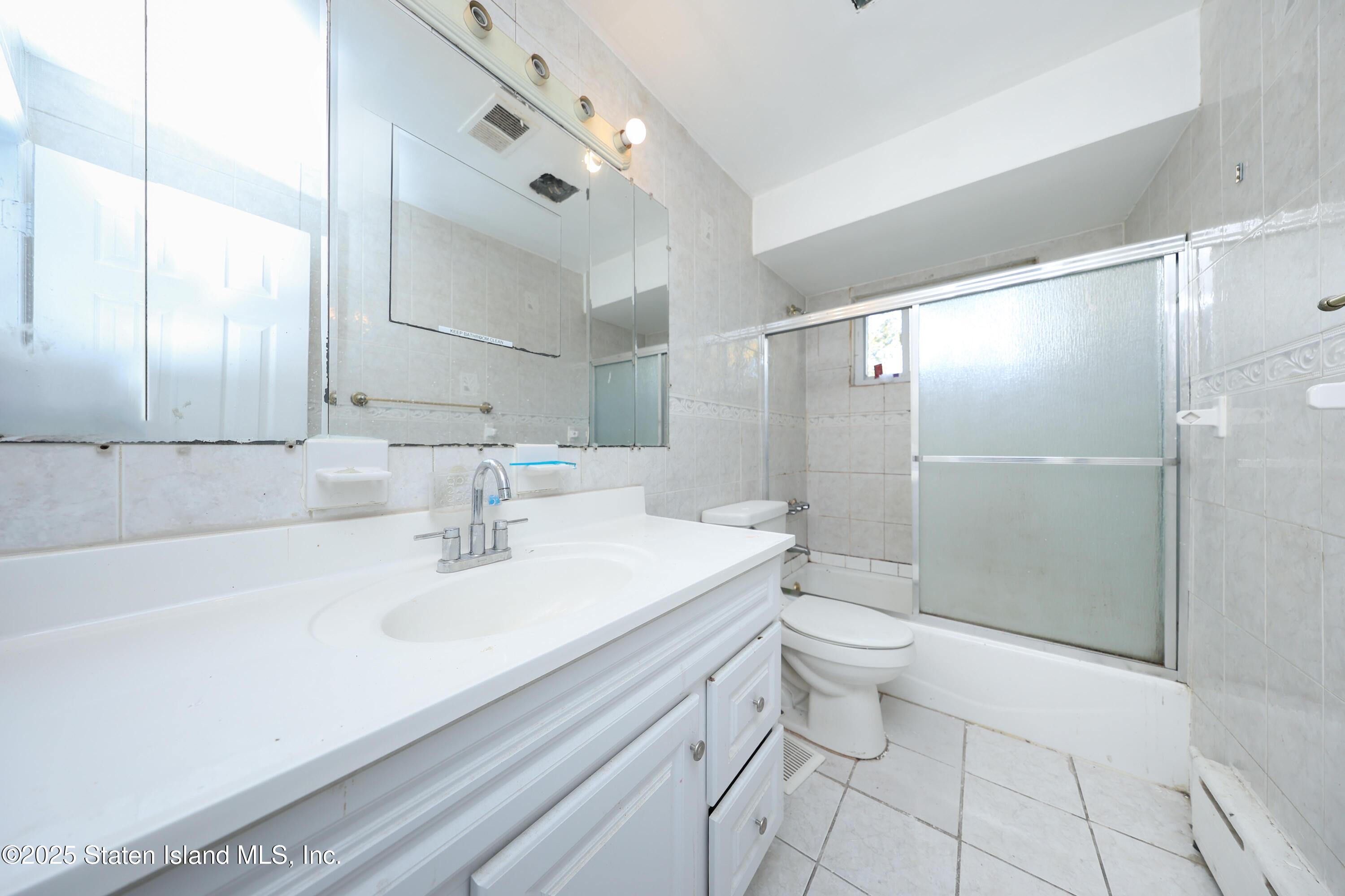 4664 Amboy Road Staten Island, NY 10312 - Photo 22 of 33 a bathroom with a sink a toilet and shower