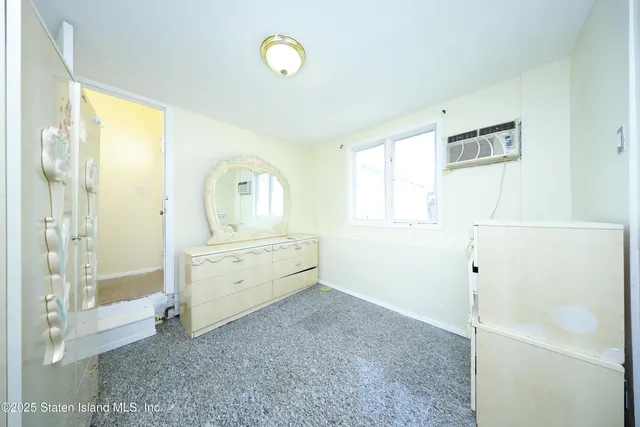 a view of a bedroom with wooden floor cabinet and window
