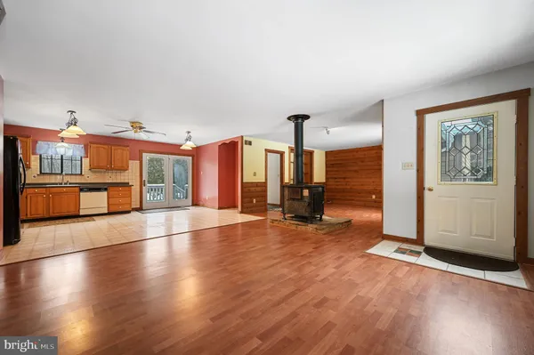 an empty room with ceiling fan and windows