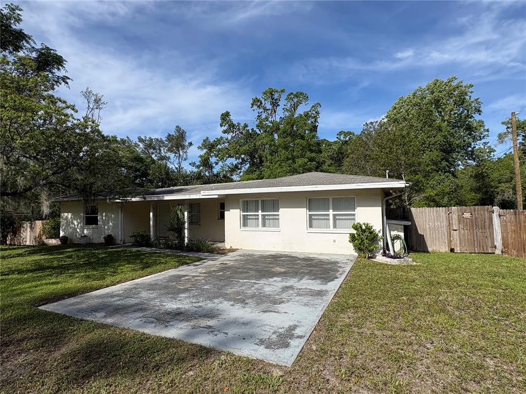 3922 South Apopka Avenue Inverness, FL 34452 - Photo 35 of 39 a front view of a house with a yard and trees