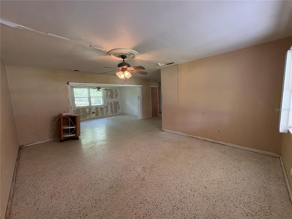 3922 South Apopka Avenue Inverness, FL 34452 - Photo 6 of 39 an empty room with windows and chandelier fan