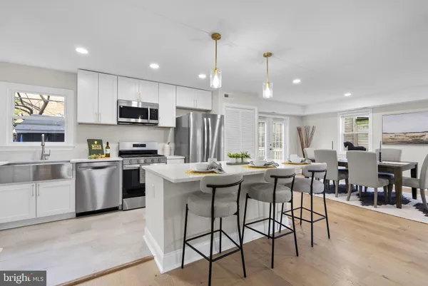 a kitchen with kitchen island granite countertop wooden floors and appliances