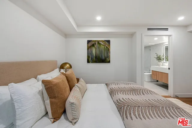 a bathroom with a double vanity sink a large mirror and a bathtub