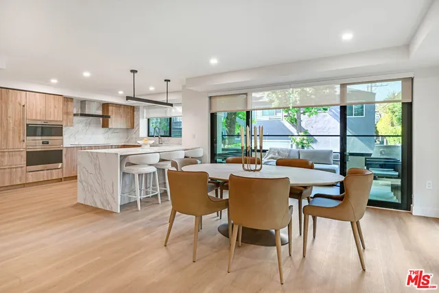 a kitchen with stainless steel appliances kitchen island granite countertop a refrigerator and a sink