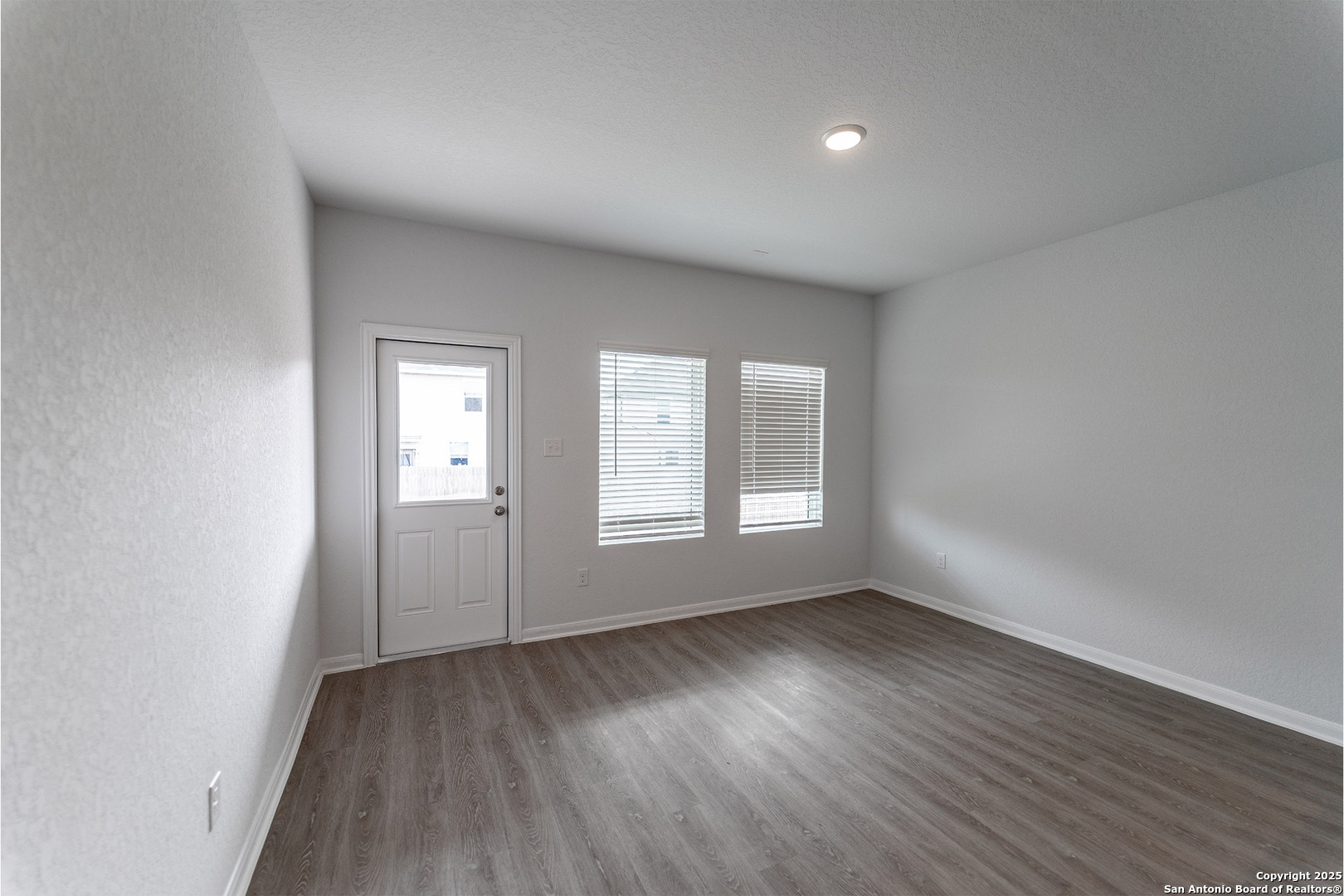 6632 Cibolo Springs Converse, TX 78109 - Photo 2 of 16 an empty room with wooden floor and windows