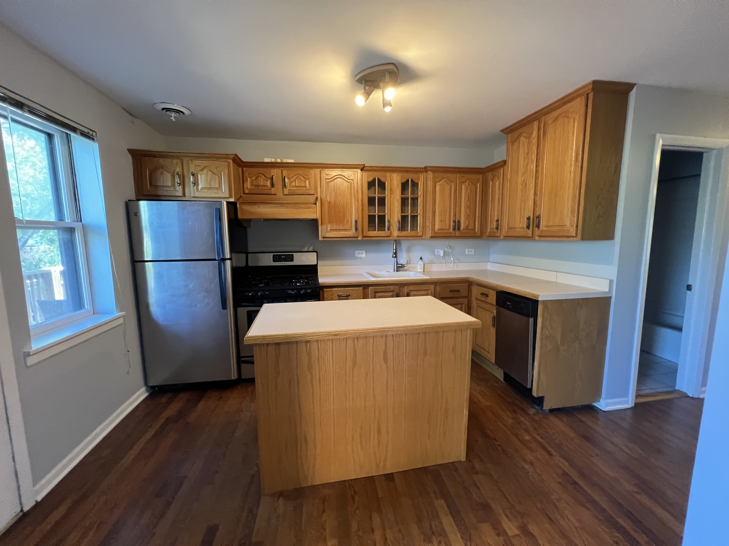 1024 West Byron Street, Unit 3W Chicago, IL 60613 - Photo 10 of 27 a kitchen with a refrigerator a stove top oven a sink and dishwasher with wooden floor