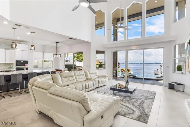a living room with furniture large windows and wooden floor
