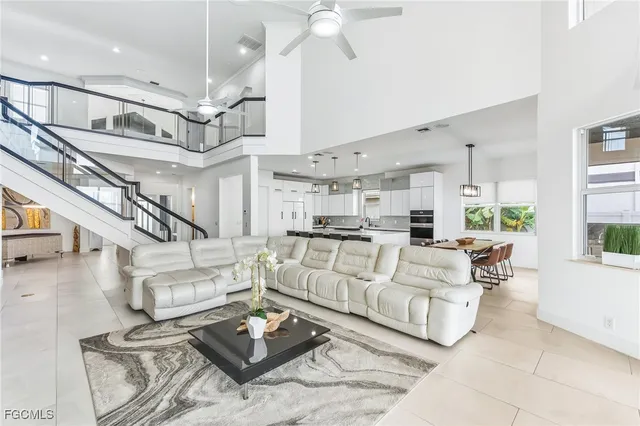 a living room with furniture kitchen view and a chandelier