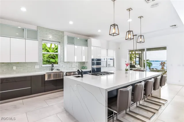 a kitchen with kitchen island granite countertop a sink a counter space appliances and cabinets