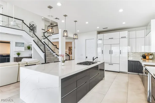 a kitchen with sink a refrigerator and white cabinets