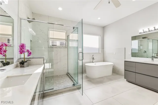a bathroom with a tub sink mirror and toilet