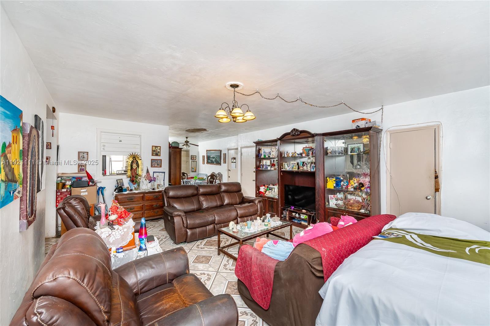 7712 Byron Avenue, Unit 4 Miami Beach, FL 33141 - Photo 5 of 12 a bedroom with furniture and a chandelier