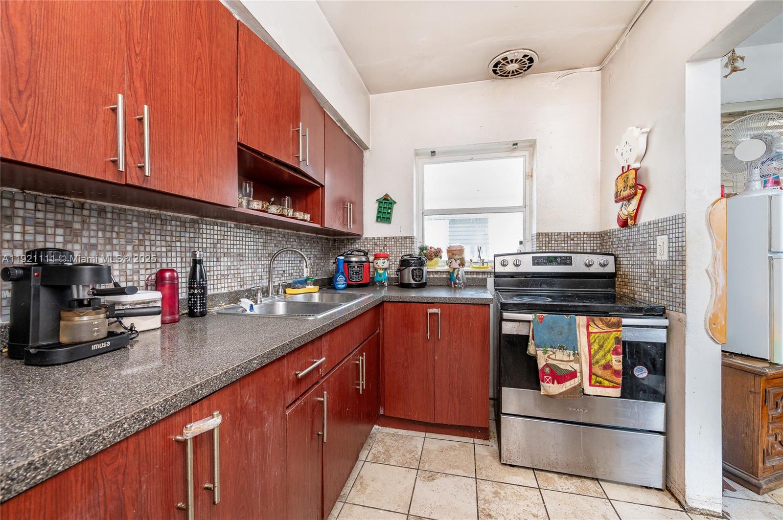 7712 Byron Avenue, Unit 4 Miami Beach, FL 33141 - Photo 8 of 12 a kitchen with stainless steel appliances granite countertop a sink stove and refrigerator