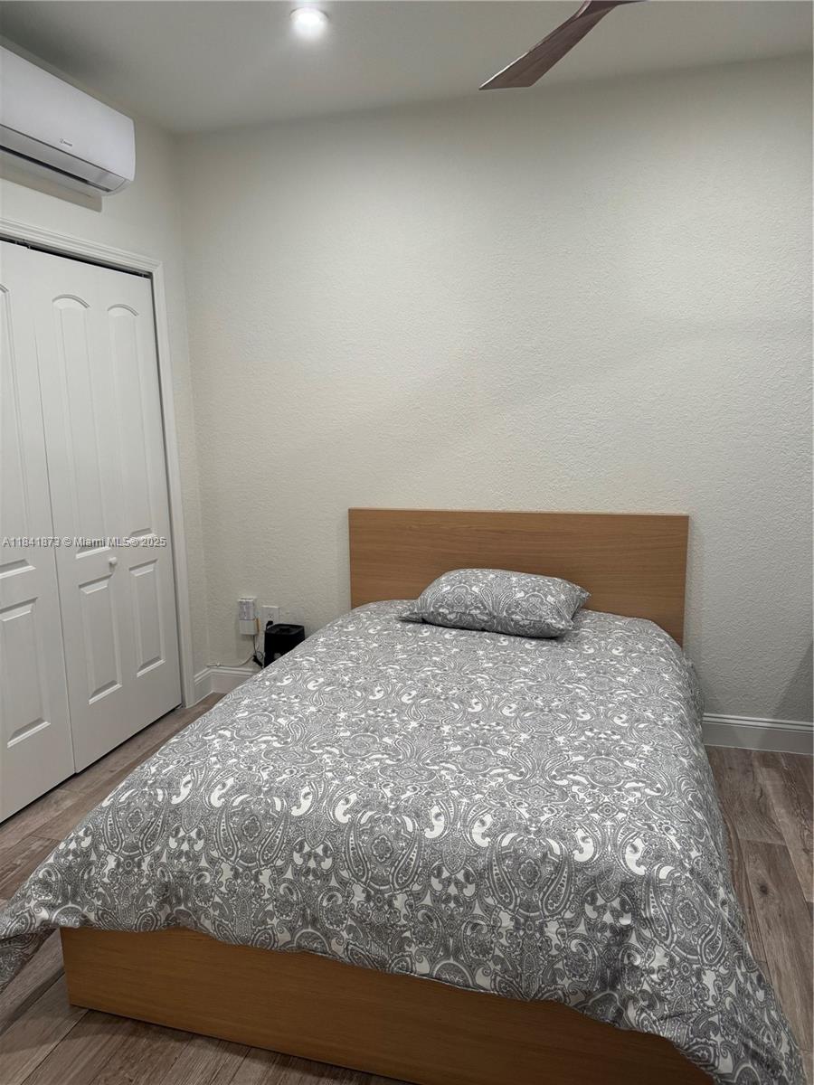 15603 Southwest 178th Street Miami, FL 33187 - Photo 6 of 11 a bedroom with a bed and wooden floor