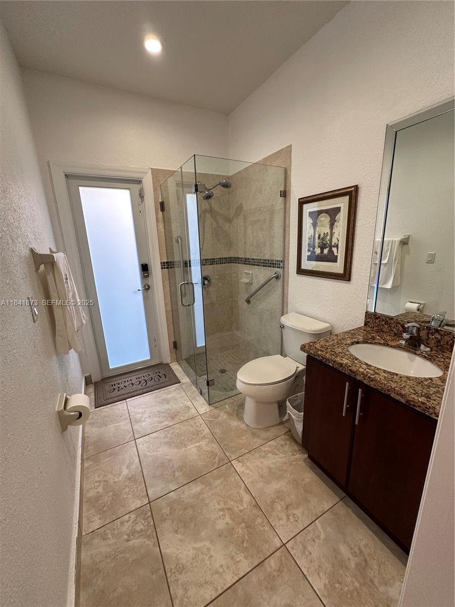 15603 Southwest 178th Street Miami, FL 33187 - Photo 8 of 11 a bathroom with a granite countertop sink toilet and shower