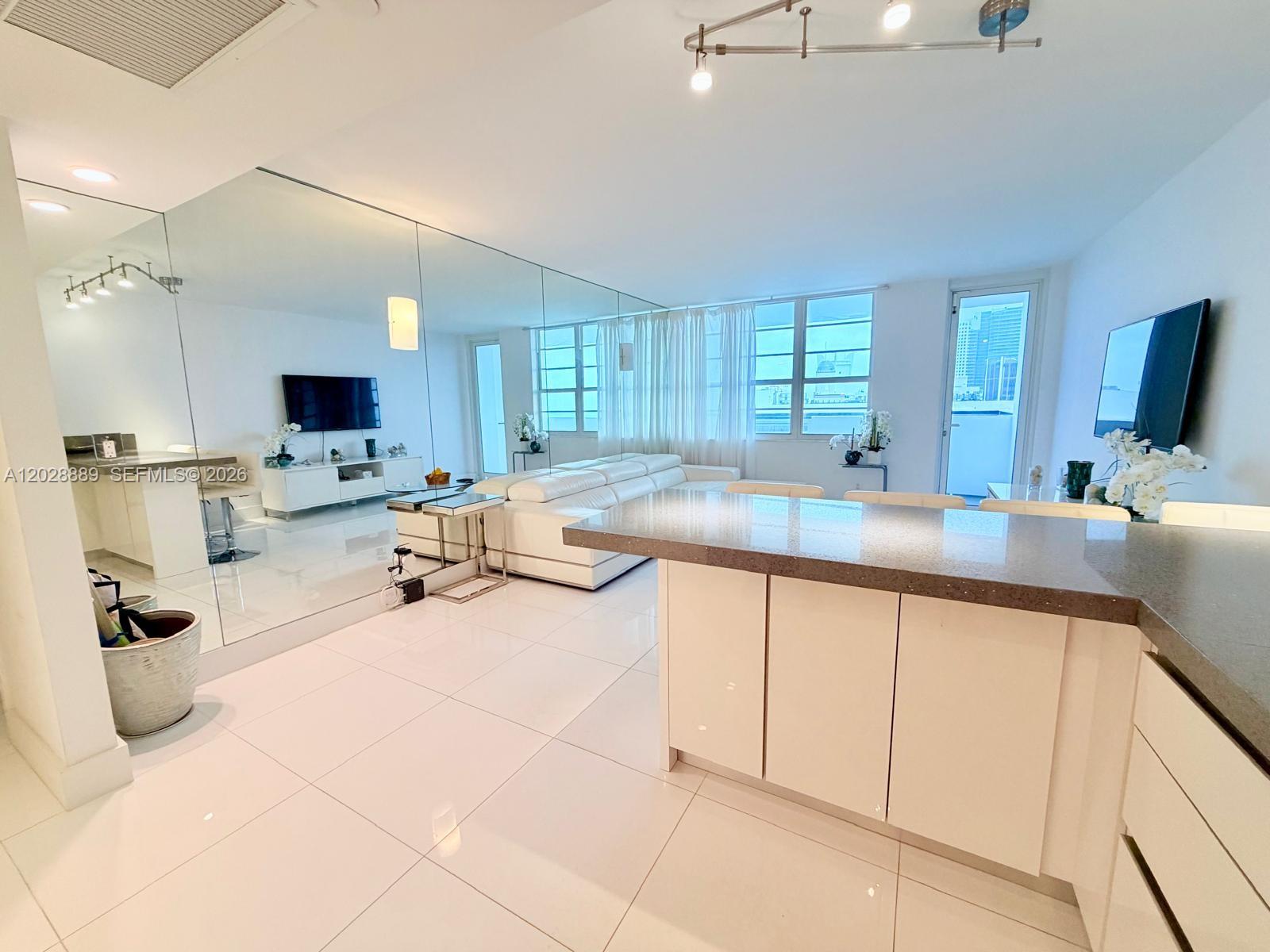 100 Lincoln Road, Unit 1504 Miami Beach, FL 33139 - Photo 2 of 17 a kitchen with stainless steel appliances a sink a stove and cabinets