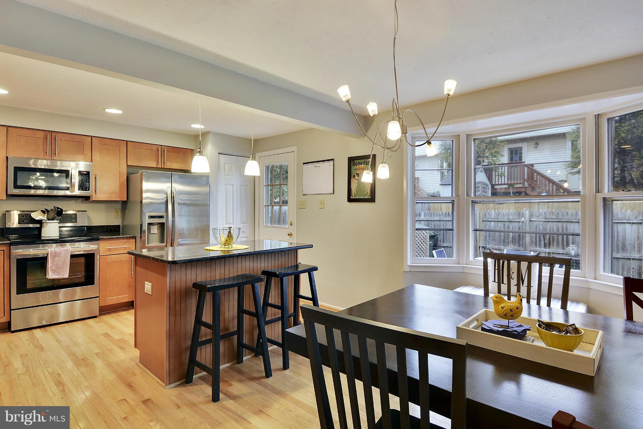 141 Annandale Road Falls Church, VA 22046 - Photo 4 of 30 a kitchen with stainless steel appliances kitchen island granite countertop a table chairs and a refrigerator