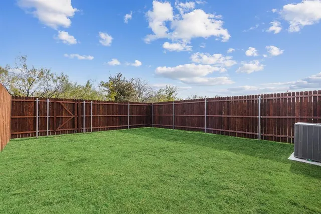 a view of a yard with wooden fence