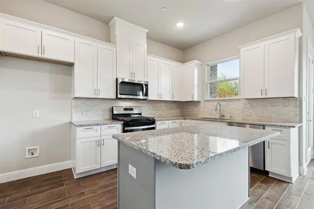 a kitchen with stainless steel appliances granite countertop a sink stove and microwave