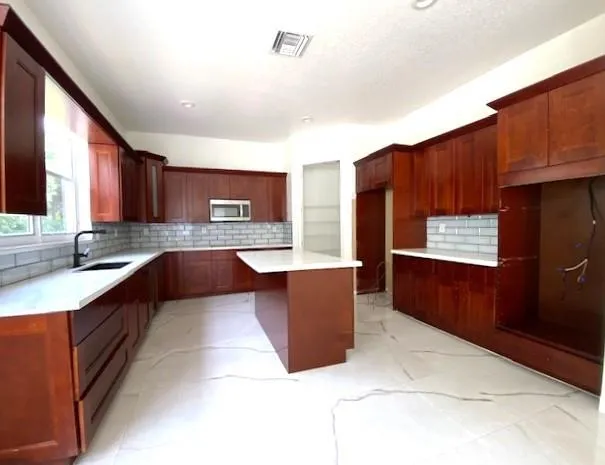 a large kitchen with stainless steel appliances granite countertop wooden cabinets a granite counter top and a sink