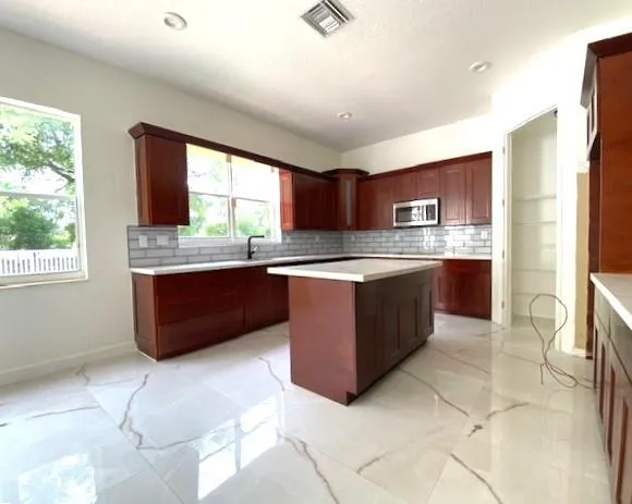 a kitchen with stainless steel appliances granite countertop a stove a sink a microwave a counter top and cabinets