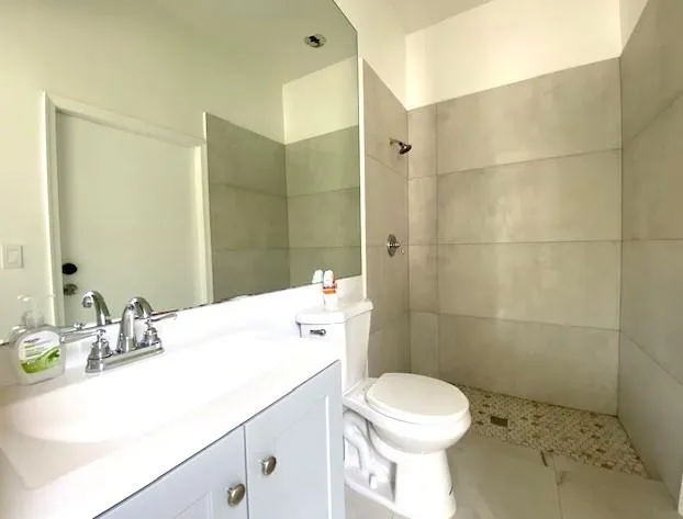 a bathroom with a sink a toilet and shower