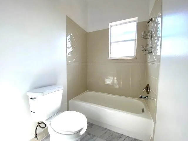 a bath room with a toilet a sink and a bath tub