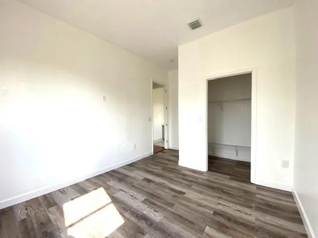 a view of an empty room and wooden floor
