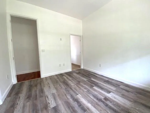 a view of an empty room with wooden floor