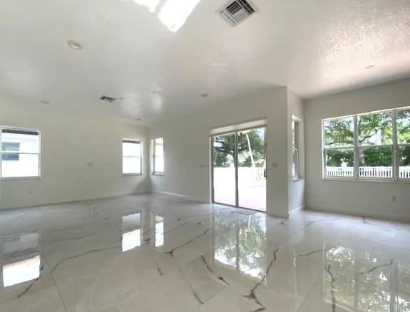 a view of empty room with floor to ceiling window and windows